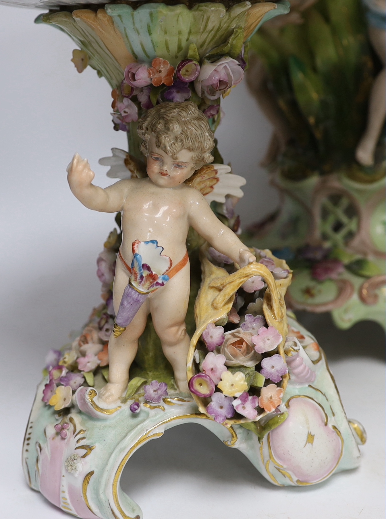 A Sitzendorf figural centrepiece, a smaller similar centrepiece and an English porcelain basket, tallest 54cm